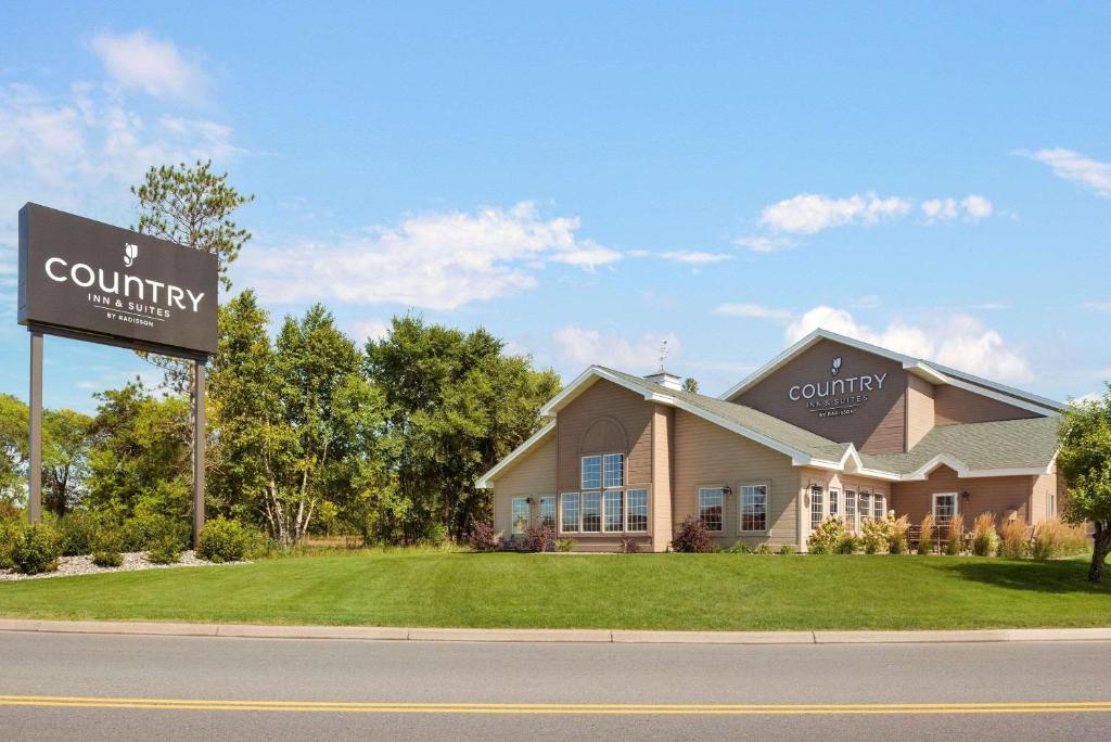 ein Haus mit einem Schild davor in der Unterkunft Country Inn & Suites by Radisson, Baxter, MN in Baxter