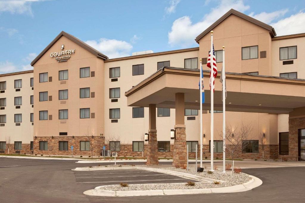 a hotel with two flags in front of it at Country Inn & Suites by Radisson, Bemidji, MN in Bemidji