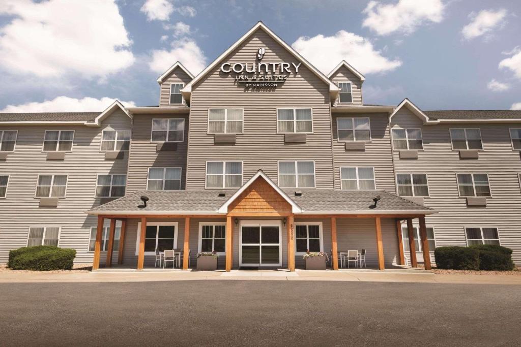a large building with a sign on top of it at Country Inn & Suites by Radisson, Brooklyn Center, MN in Brooklyn Center