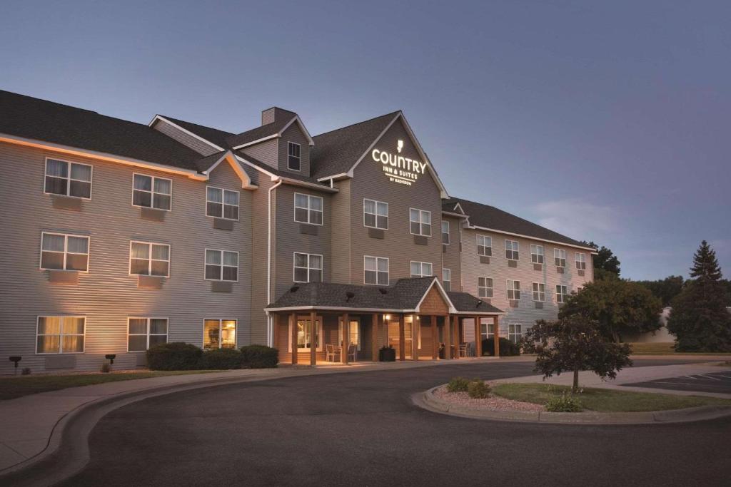 a large building with a sign on the front of it at Country Inn & Suites by Radisson, Brooklyn Park - Brooklyn Center, MN in Brooklyn Center