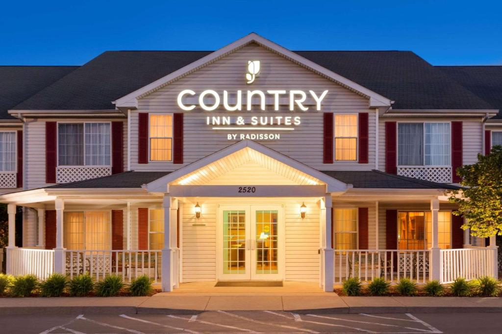 Country Inn & Suites by Radisson, Nevada, MO في Nevada: مبنى به نزل و اجنحة ريفية