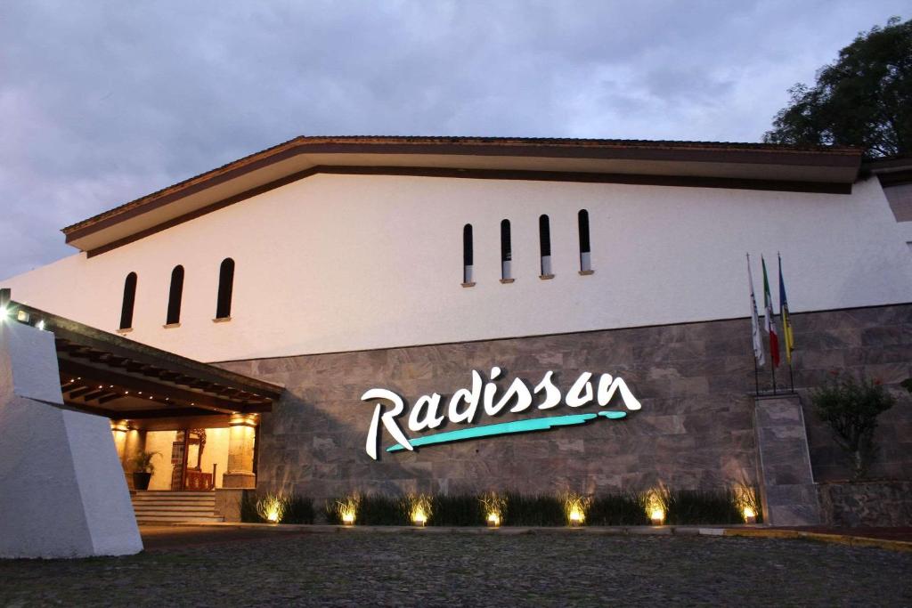 un bâtiment avec un panneau sur son côté dans l'établissement Radisson Hotel Tapatio Guadalajara, à Guadalajara