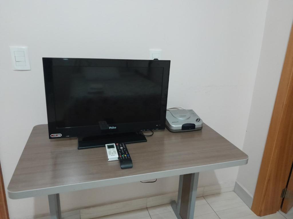 uma televisão sentada numa mesa com um comando à distância em Hotel e Restaurante São Cristovão 
