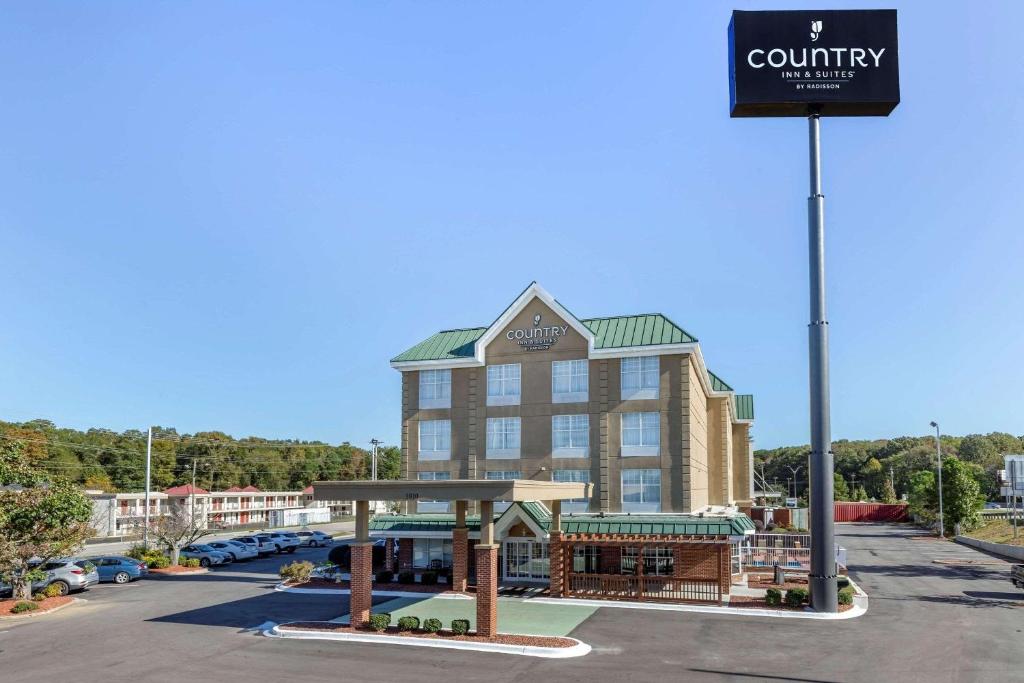 ランバートンにあるCountry Inn & Suites by Radisson, Lumberton, NCの駐車場の看板のある建物