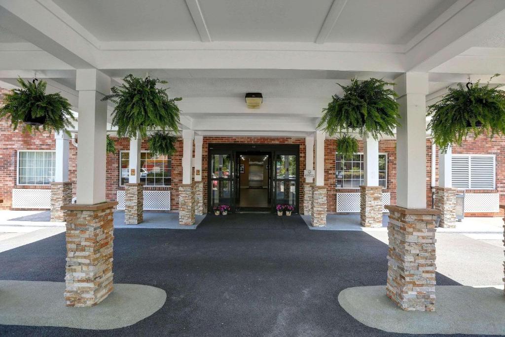 a hallway with two potted plants in a building at Country Inn & Suites by Radisson, Charlotte I-85 Airport, NC in Charlotte