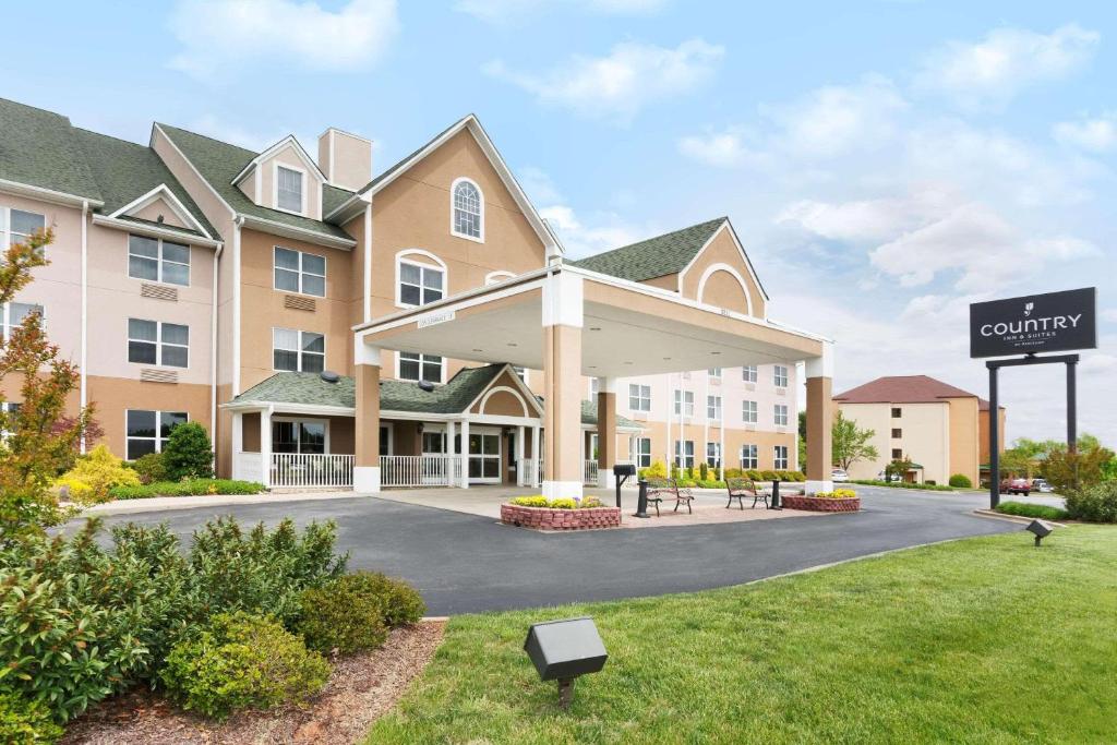 Country Inn & Suites by Radisson, Burlington Elon , NC في برلنغتون: تقديم فندق مع وجود لافته في الساحه