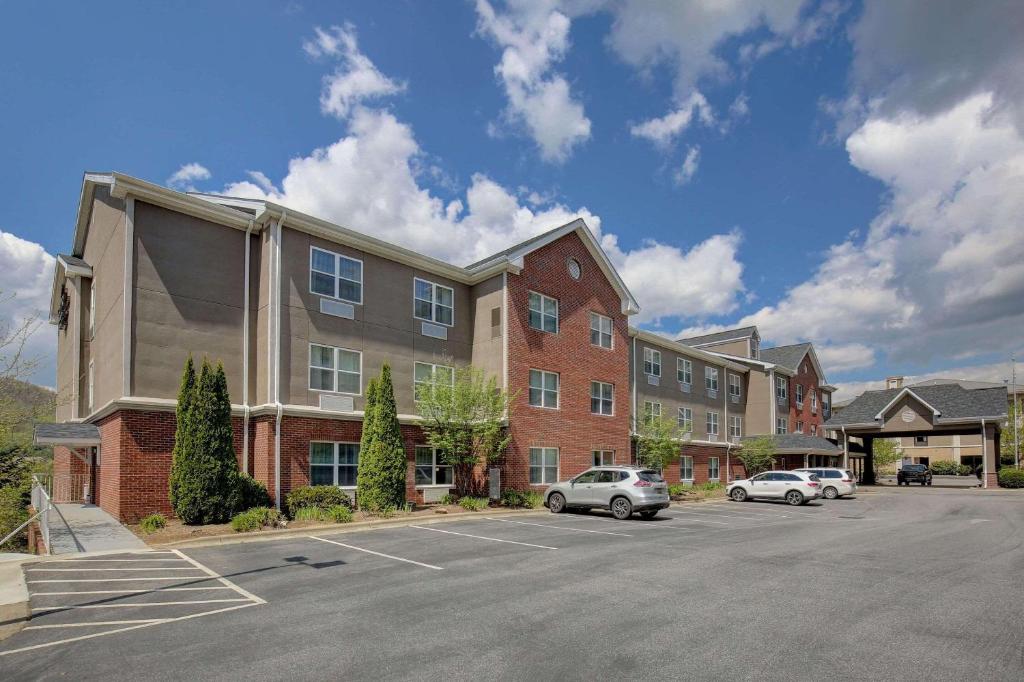 a parking lot with cars parked in front of a building at Country Inn & Suites by Radisson, Boone, NC in Boone