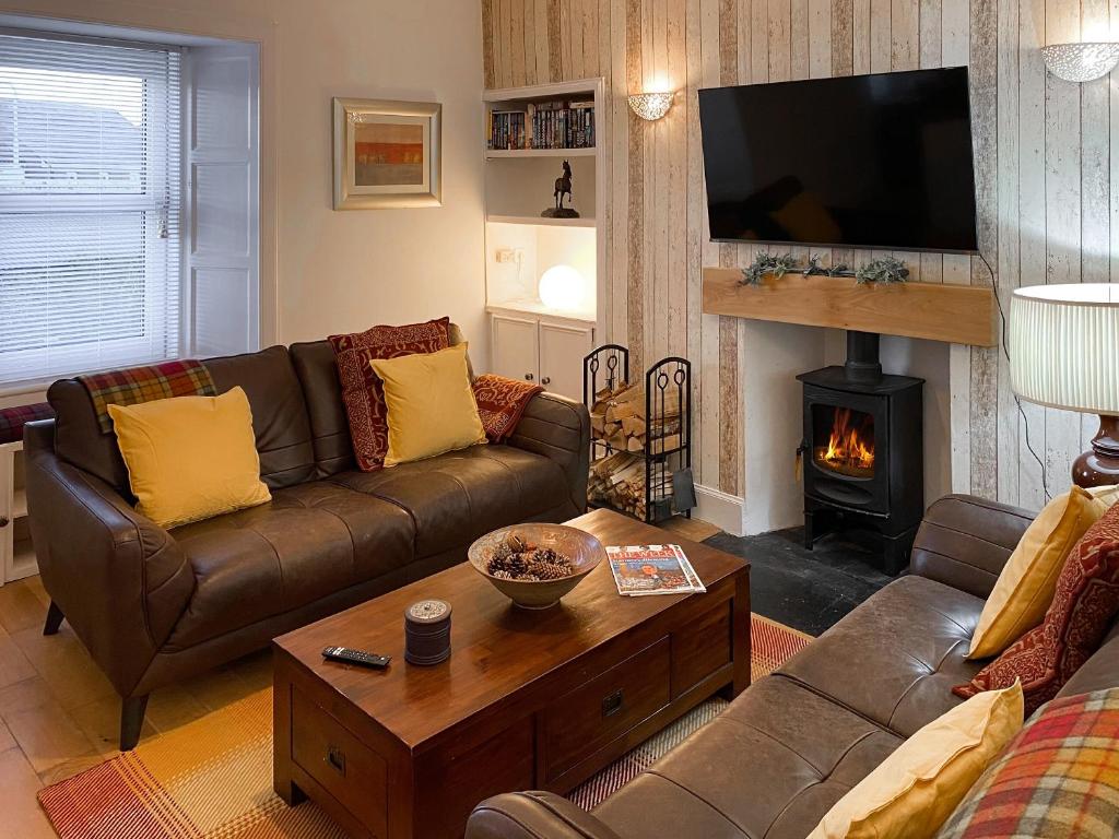 a living room with a couch and a fireplace at The Thistle in Auchtermuchty