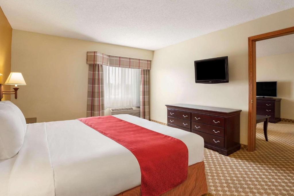 a hotel room with a bed and a television at Country Inn & Suites by Radisson, Lincoln North Hotel and Conference Center, NE in Lincoln