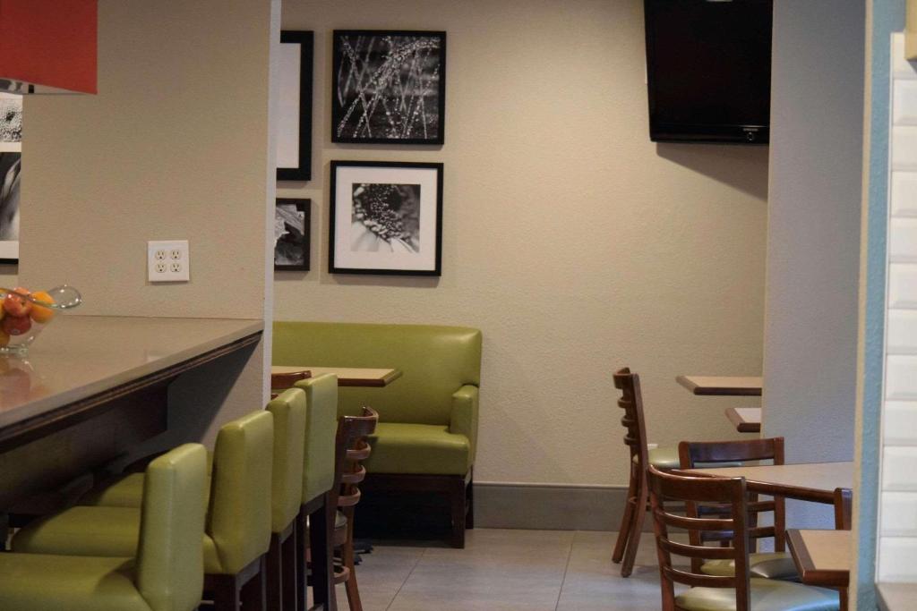 a restaurant with green chairs and a counter at Country Inn & Suites by Radisson, Lincoln North Hotel and Conference Center, NE in Lincoln