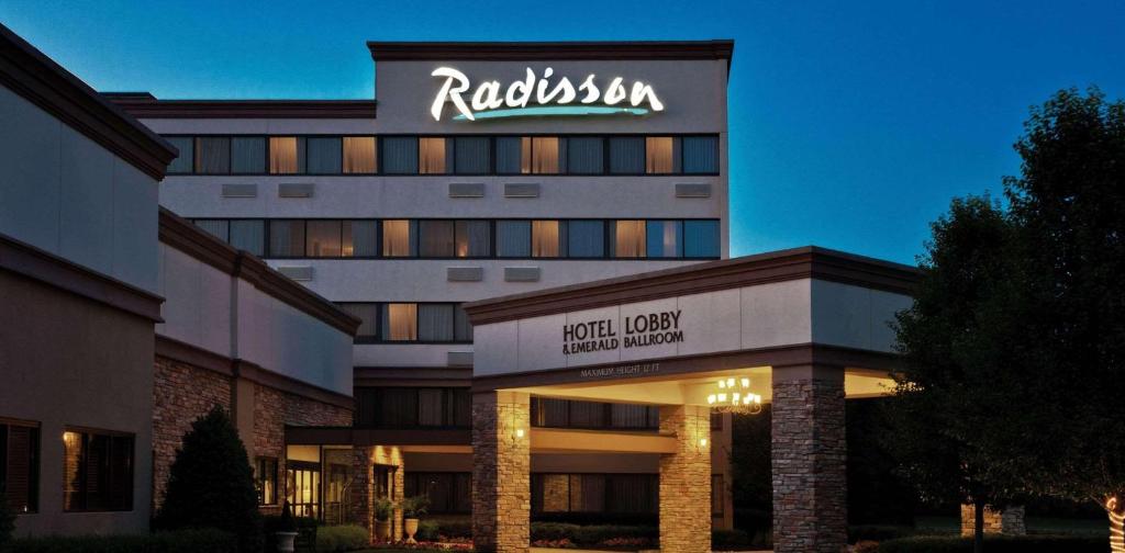 a hotel with a sign on top of a building at Radisson Hotel Freehold in Freehold