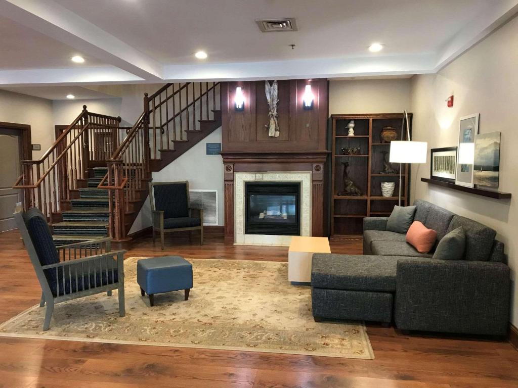 a living room with a couch and a fireplace at Country Inn & Suites by Radisson, Lake George Queensbury, NY in Lake George