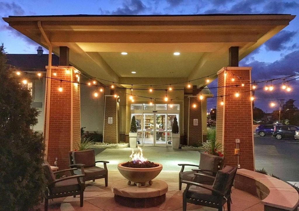 a patio with a fountain with chairs and lights at Country Inn & Suites by Radisson, Rochester-Pittsford-Brighton, NY in Rochester