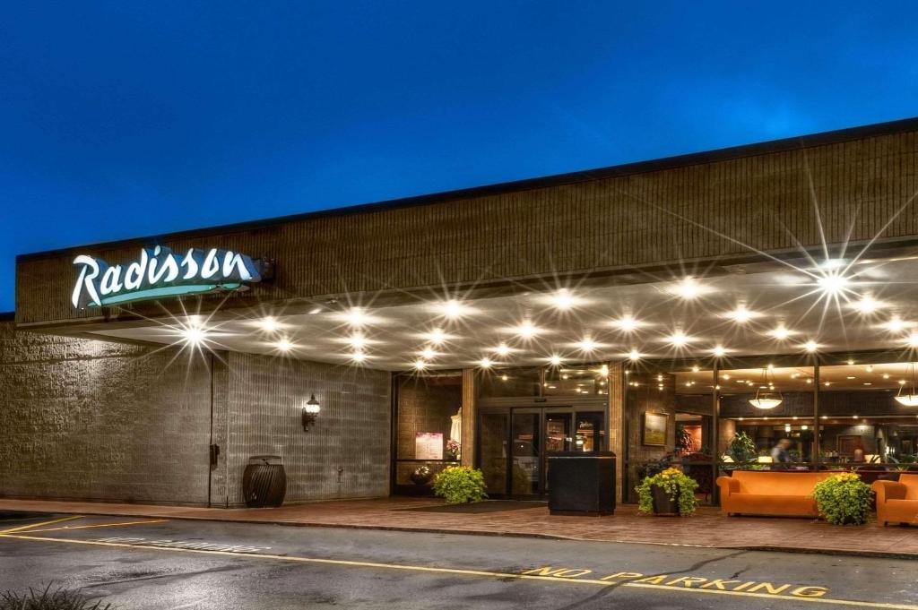 a restaurant with lights on the front of a building at Radisson Hotel Corning in Corning