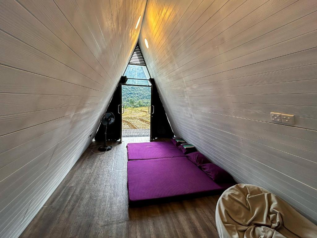 una habitación con una esterilla de yoga púrpura en una tienda de campaña en A frame Riverston, en Matale