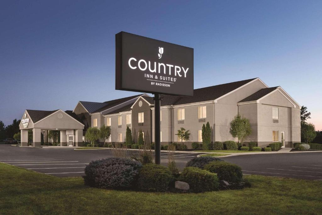 un cartel frente a un edificio con hotel en Country Inn & Suites by Radisson, Port Clinton, OH, en Port Clinton