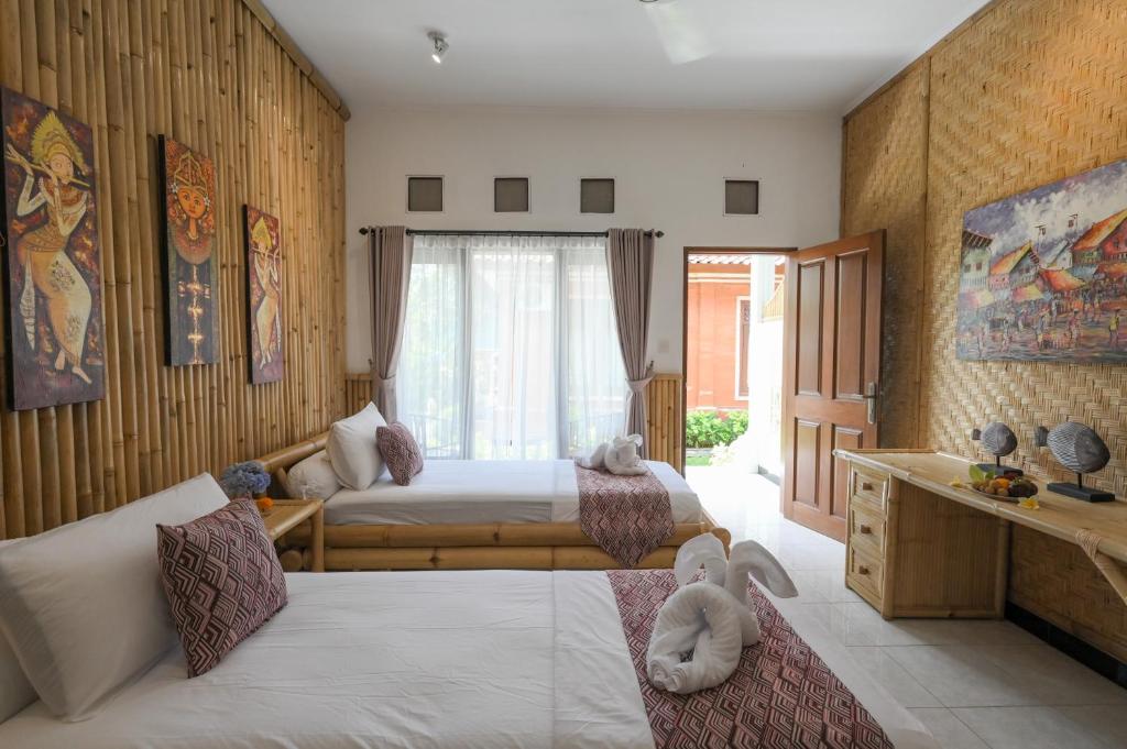 Tiga Naga Villa في دينباسار: غرفة نوم بسريرين يوجد عليها حيوانات محشوة