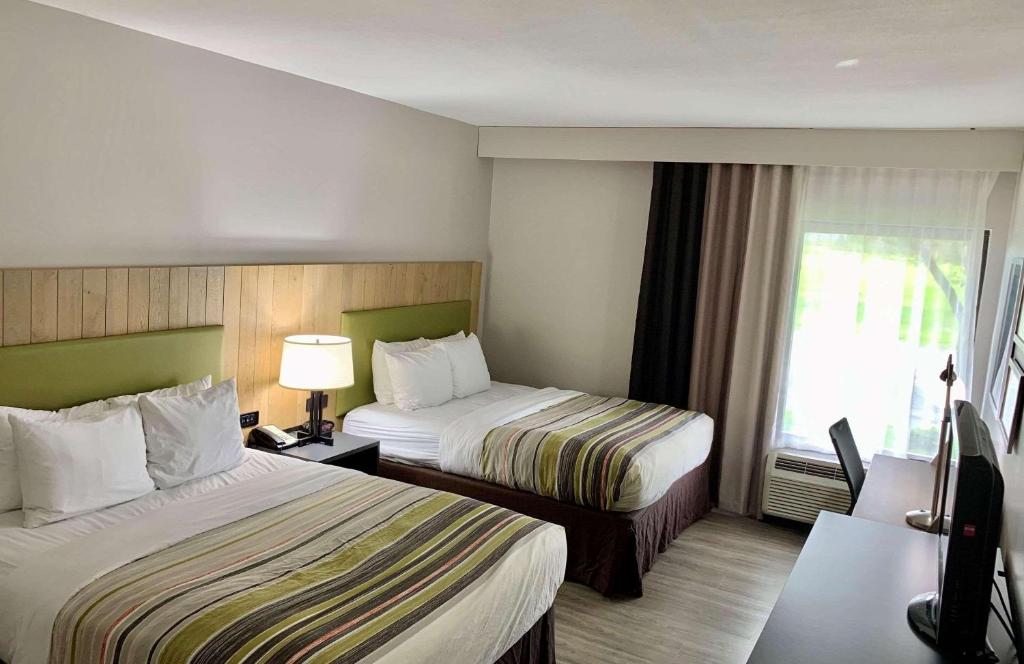 Habitación de hotel con 2 camas y ventana en Country Inn & Suites by Radisson, Sandusky South, OH en Milan