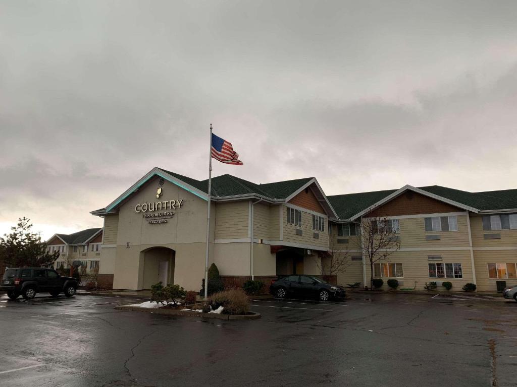 a building with an american flag on top of it at Country Inn & Suites by Radisson, Bend, OR in Bend