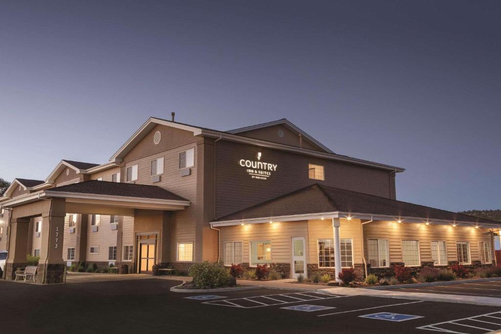 een hotelgebouw met een parkeerplaats ervoor bij Country Inn & Suites by Radisson, Prineville, OR in Prineville