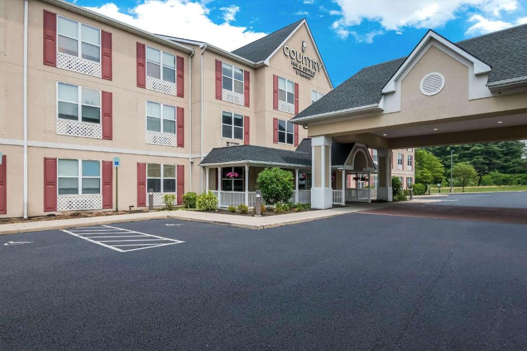 ハリスバーグにあるCountry Inn & Suites by Radisson, Harrisburg Northeast - Hersheyの駐車場付きのホテルの正面の景色