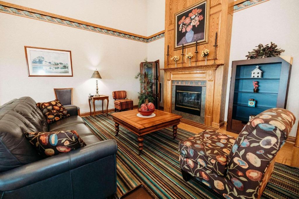 Country Inn & Suites by Radisson, Lancaster Amish Country , PA في لانكستر: غرفة معيشة مع أريكة ومدفأة
