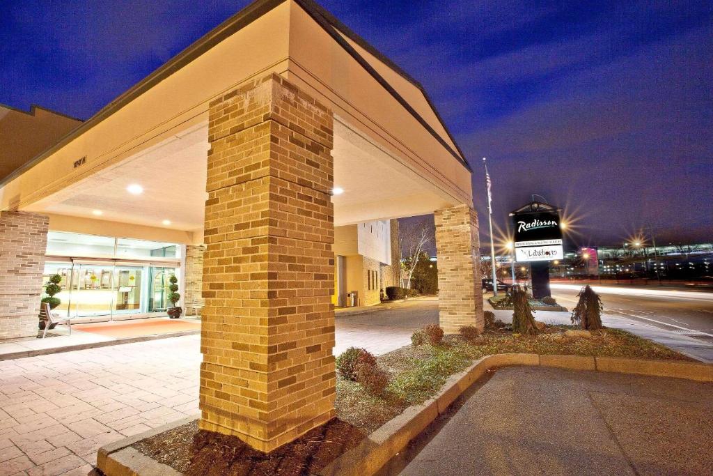 um pilar de tijolo em frente a um edifício à noite em Radisson Hotel Providence Airport em Warwick