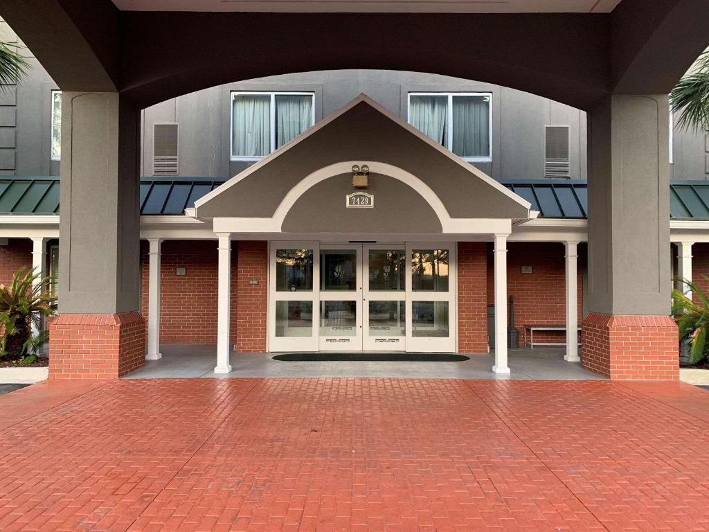 um edifício com uma porta grande e um pátio de tijolos em Country Inn & Suites By Radisson, Charleston North, SC em Charleston