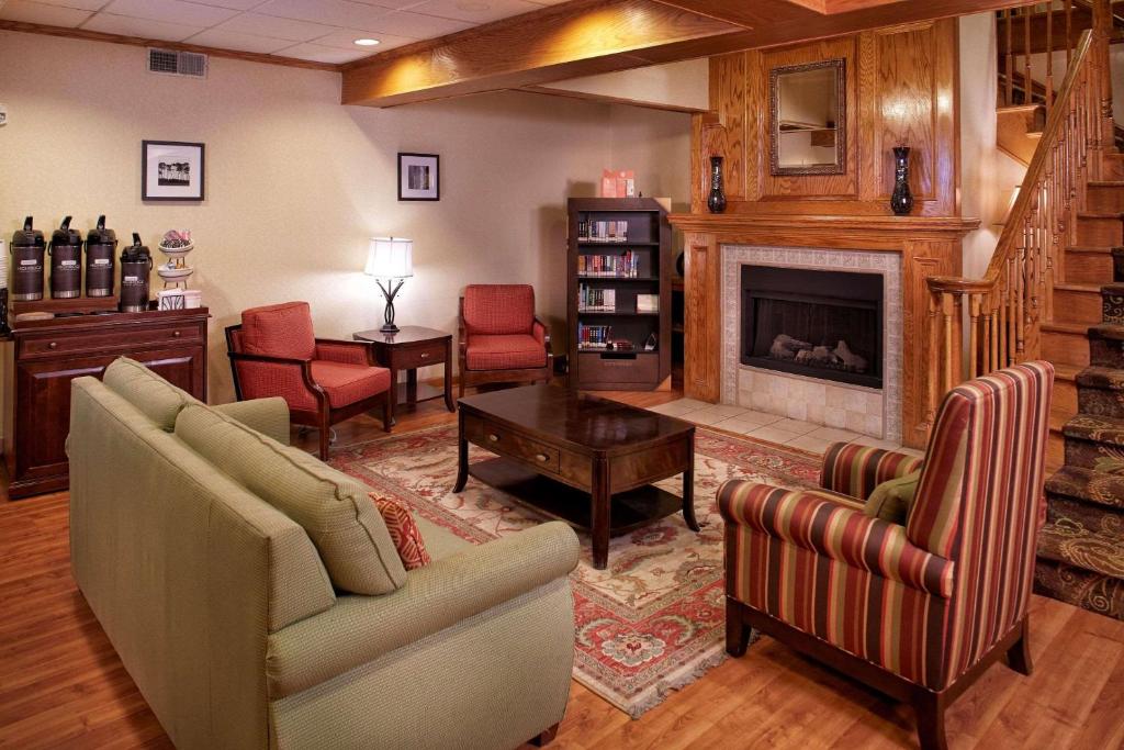 sala de estar con 2 sofás y chimenea en Country Inn & Suites by Radisson, Columbia Airport, SC, en Columbia