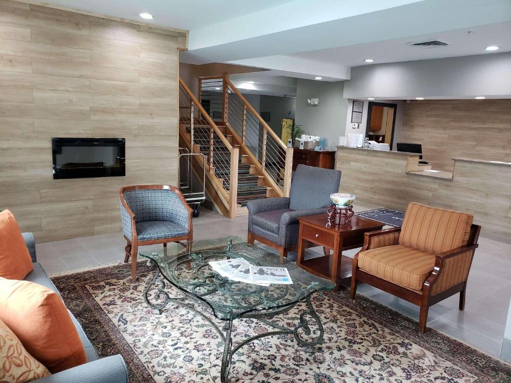 een woonkamer met een bank en stoelen en een tv bij Country Inn & Suites by Radisson, Rock Hill, SC in Rock Hill