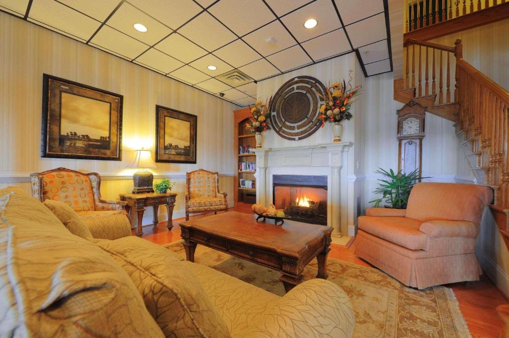 sala de estar con sofá y chimenea en Country Inn & Suites by Radisson, Orangeburg, SC, en Orangeburg