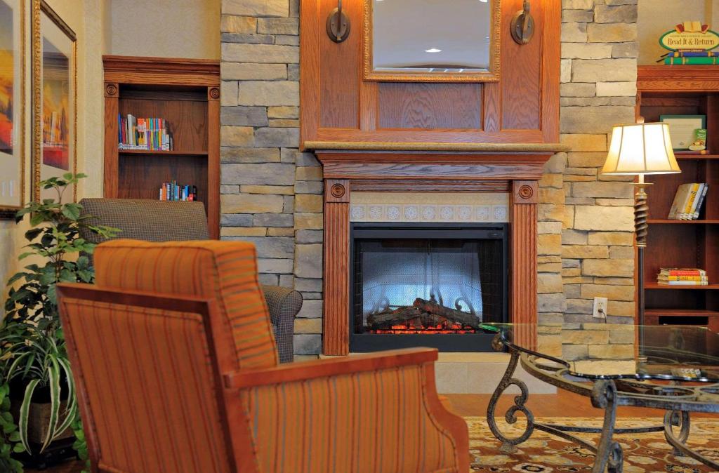 ein Wohnzimmer mit einem Kamin und einem Stuhl in der Unterkunft Country Inn & Suites by Radisson, Columbia at Harbison, SC in Columbia