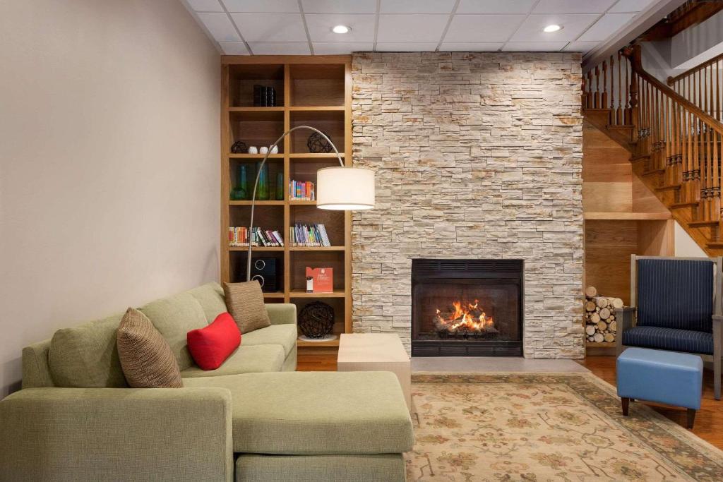 sala de estar con sofá y chimenea en Country Inn & Suites by Radisson, Summerville, SC, en Summerville