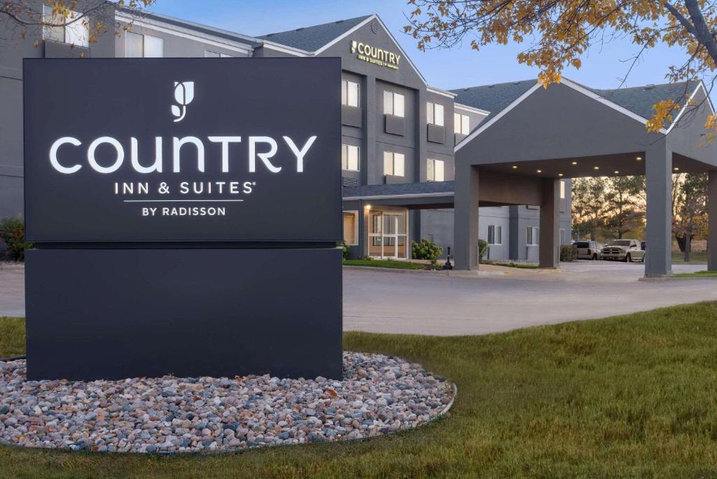 una señal para una posada del condado y suites frente a un edificio en Country Inn & Suites by Radisson, Brookings, en Brookings