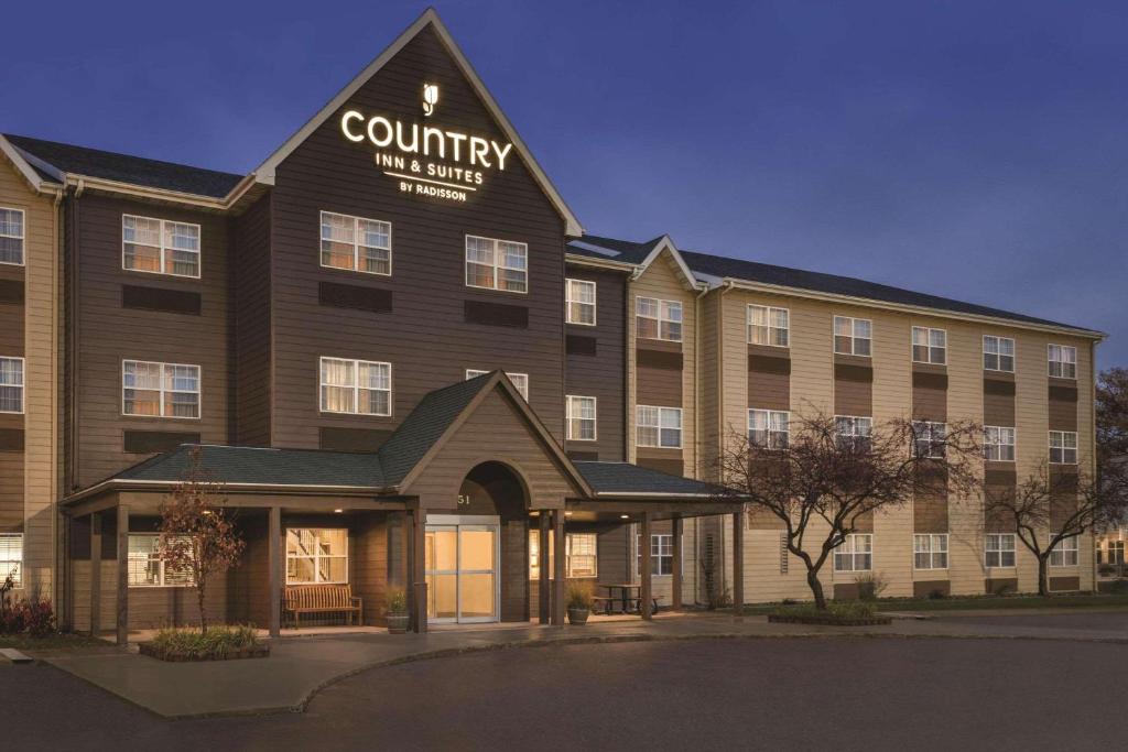 un gran edificio con un cartel que lee posada rural y suites en Country Inn & Suites by Radisson, Dakota Dunes, SD, en Dakota Dunes
