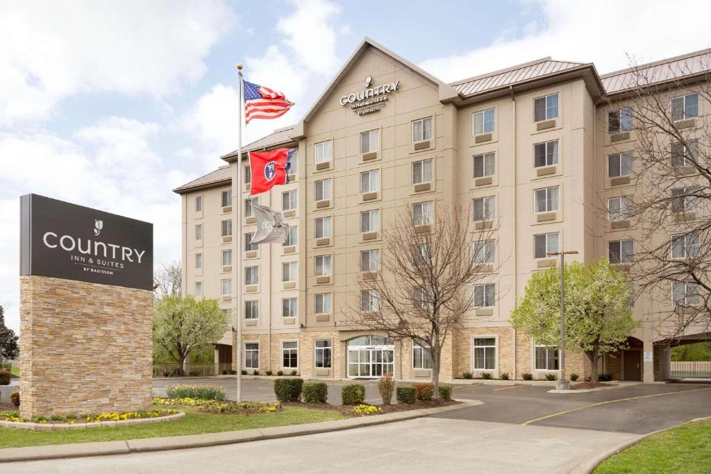 a building with two flags in front of it at Country Inn & Suites by Radisson Nashville Airport TN in Nashville