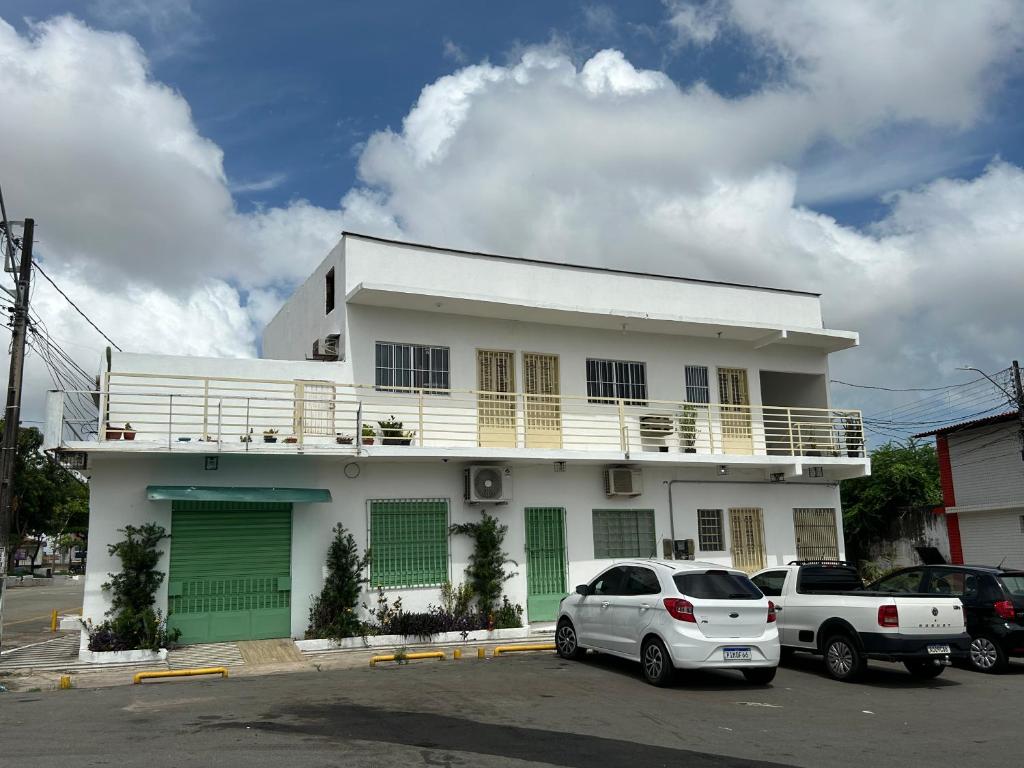 Una casa blanca con autos estacionados frente a ella. en Betesda 2197F, en São Luís