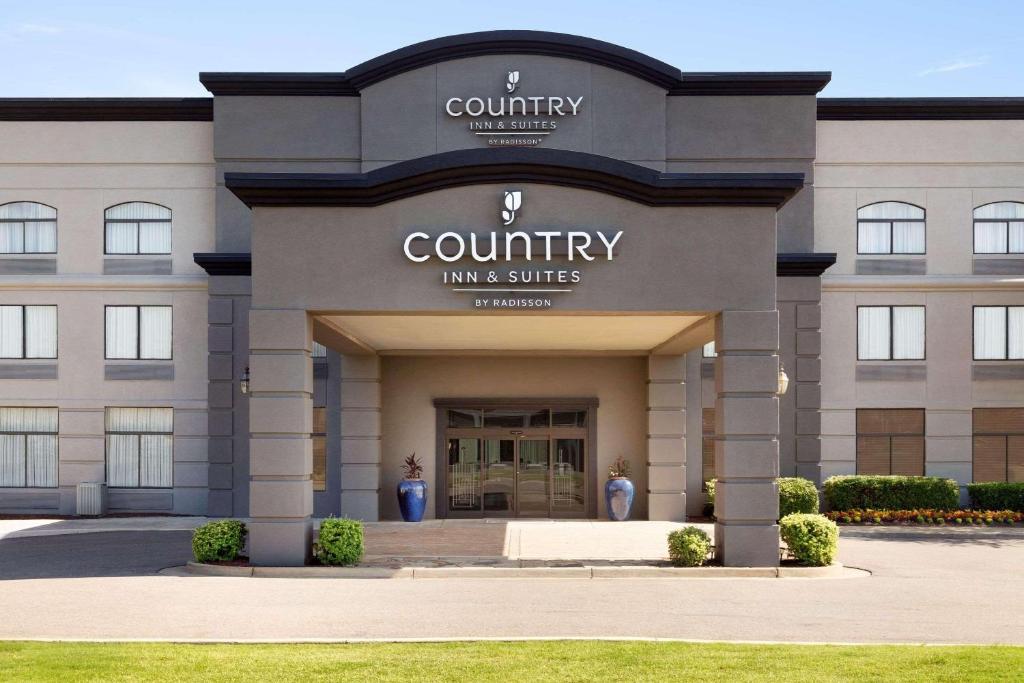 um edifício com entrada para uma estalagem e suites do condado em Country Inn & Suites by Radisson, Wolfchase-Memphis, TN em Memphis