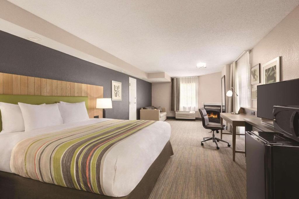 a hotel room with a bed and a desk at Country Inn & Suites by Radisson, Pigeon Forge South, TN in Pigeon Forge