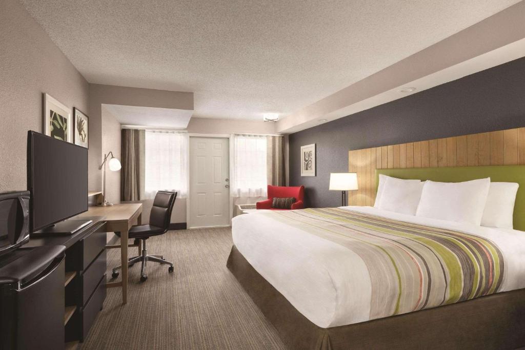 a hotel room with a bed and a desk with a computer at Country Inn & Suites by Radisson, Pigeon Forge South, TN in Pigeon Forge