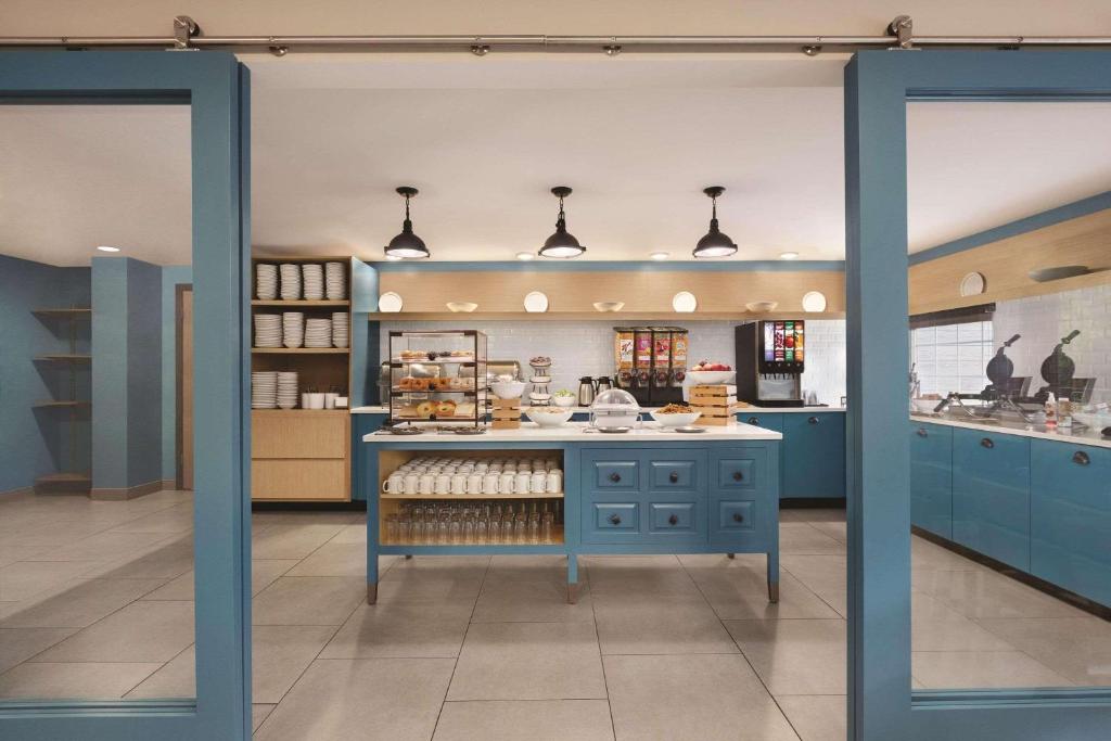 a large kitchen with blue cabinets at Country Inn & Suites by Radisson, Pigeon Forge South, TN in Pigeon Forge
