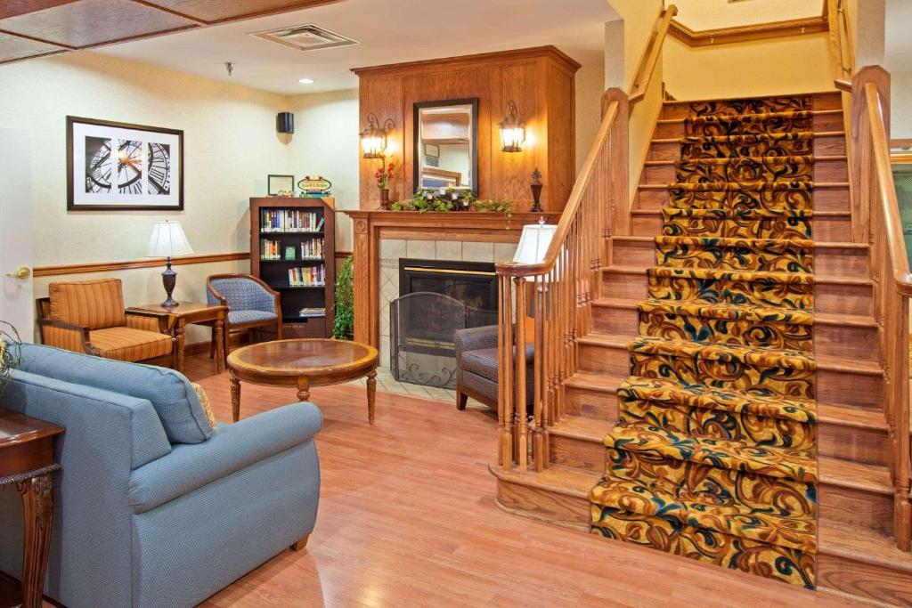 sala de estar con escalera y chimenea en Country Inn & Suites by Radisson, Knoxville West, TN, en Knoxville