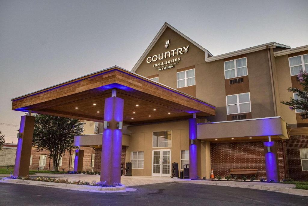 - une vue de devant d'un bâtiment avec des lumières bleues dans l'établissement Country Inn & Suites by Radisson, Harlingen, TX, à Harlingen