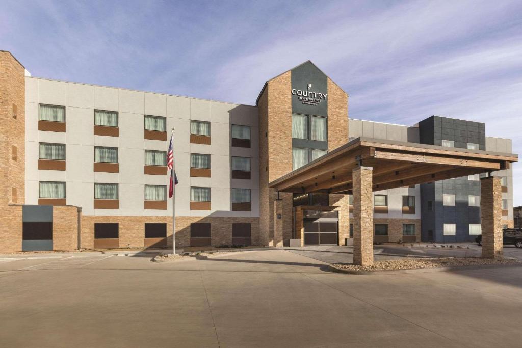 ein großes Gebäude mit einer Flagge davor in der Unterkunft Country Inn & Suites by Radisson, Lubbock Southwest, TX in Lubbock