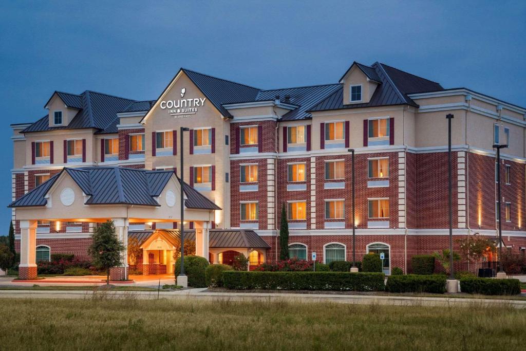 un grand bâtiment avec un panneau à l'avant dans l'établissement Country Inn & Suites by Radisson, College Station, TX, à College Station