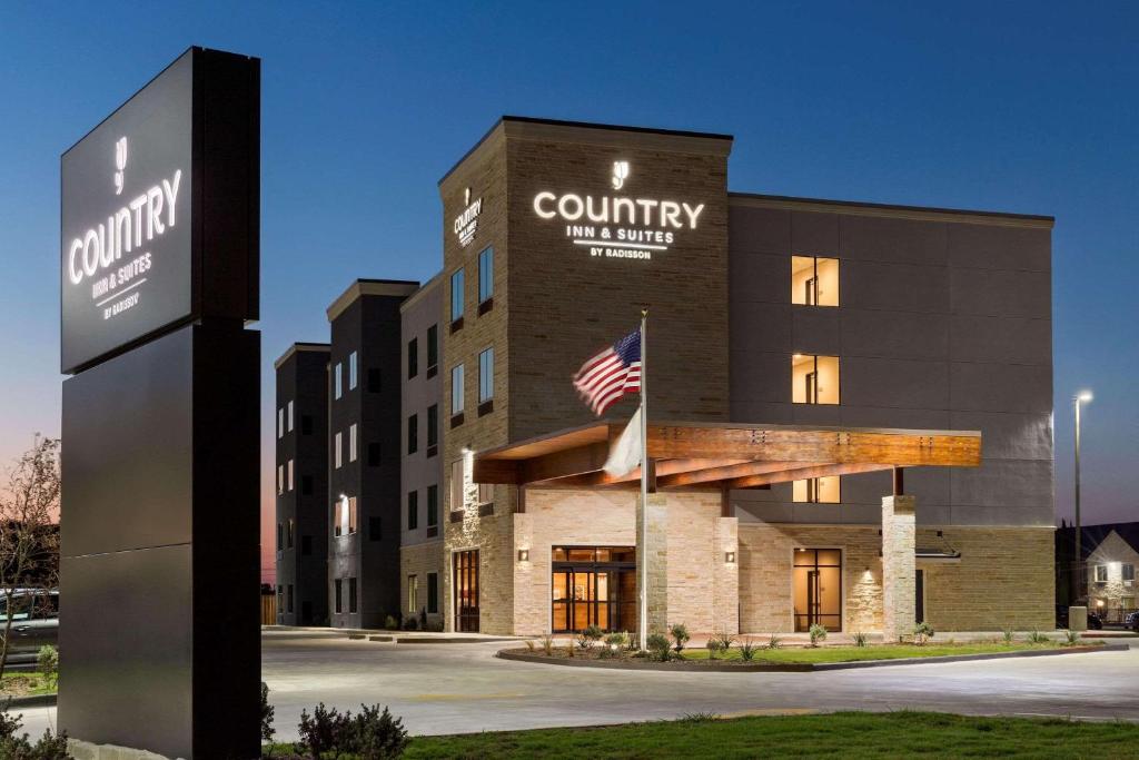 ein Gebäude mit amerikanischer Flagge davor in der Unterkunft Country Inn & Suites by Radisson, New Braunfels, TX in New Braunfels