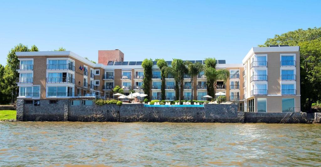 una fila de edificios de apartamentos junto a una masa de agua en Radisson Hotel Colonia del Sacramento, en Colonia del Sacramento