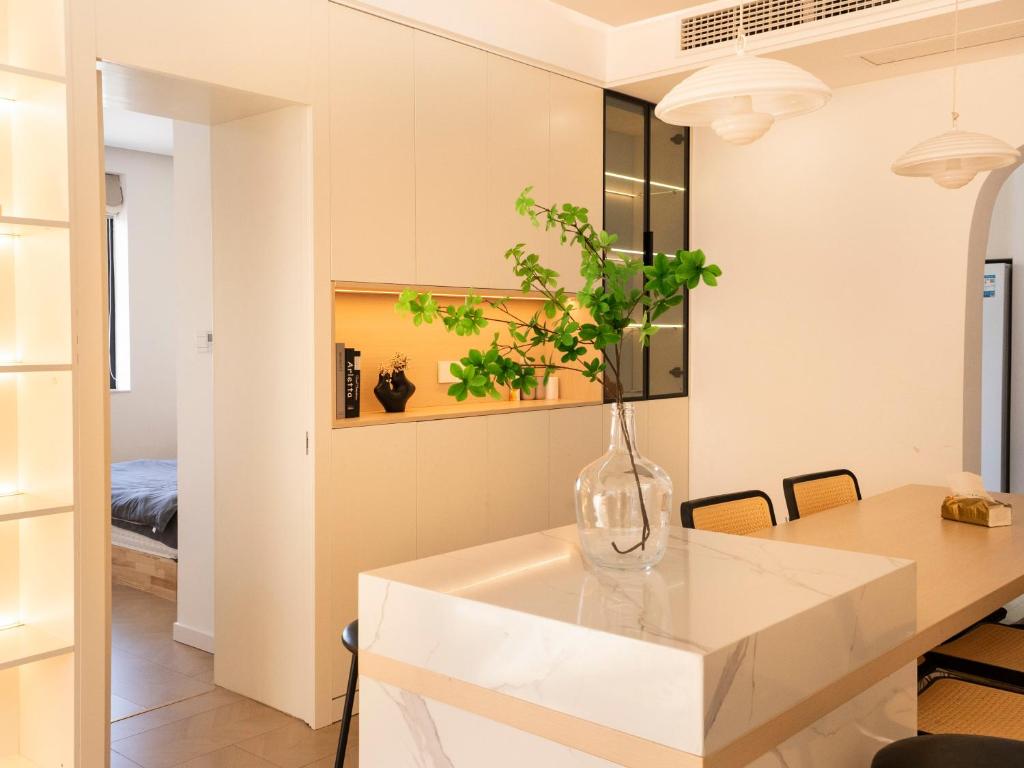uma cozinha com uma mesa e um vaso com uma planta em Three Bedroom Apartment near Xintiandi em Xangai