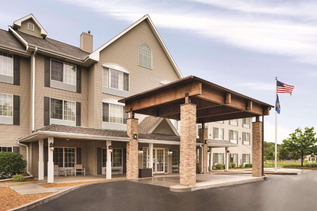 a large house with an awning in front of it at Country Inn & Suites by Radisson, West Bend, WI in West Bend