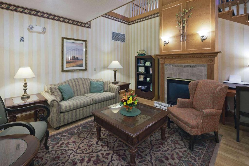 a living room with a couch and a fireplace at Country Inn & Suites by Radisson, Prairie du Chien, WI in Prairie du Chien